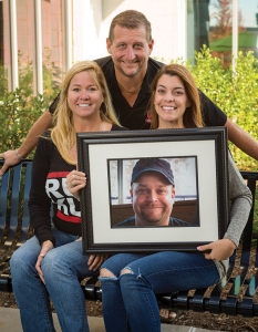 Robert Royster, standing, Ashley Royster, left, and Amy Pilz, holding a photo of the late Ryan Pilz, have grown Ruckus Pizza, Pasta & Spirits from a bar 18 years ago into a family-friendly restaurant with four locations. 