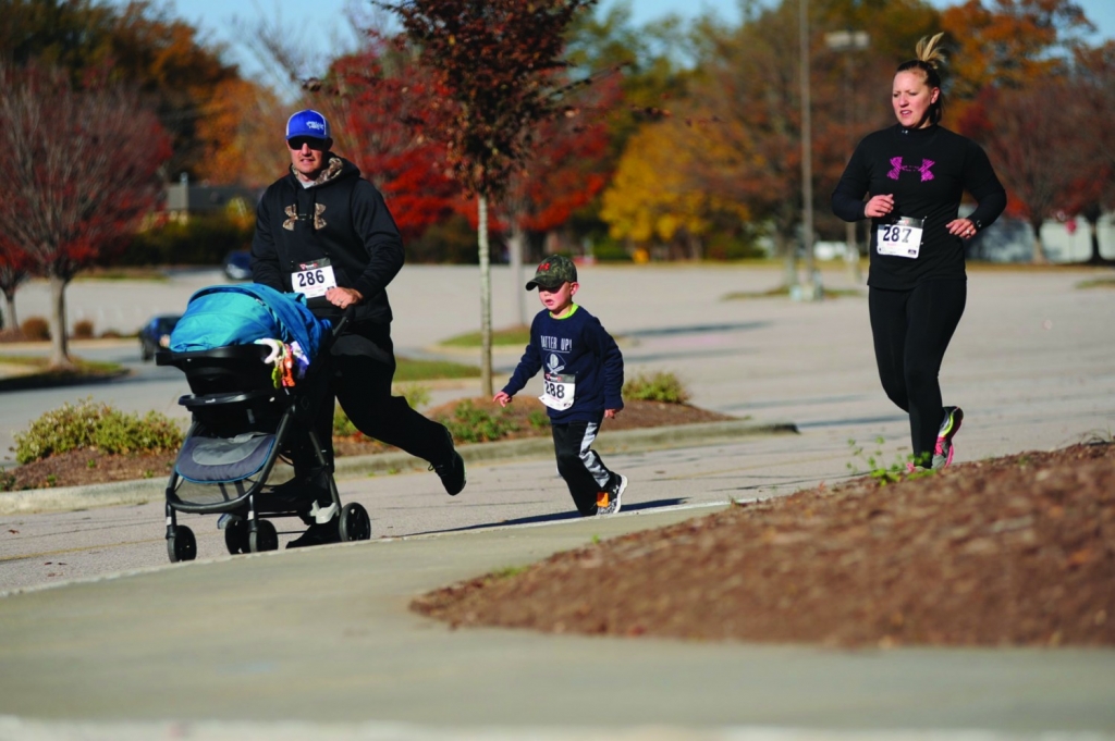 Scotty, Lane and Kelley Bradshaw run together at the Cozy Toes Fun Run. Lane Bradshaw, lower left, shows off his prize for completing a mile. Parents who eat healthy and exercise tend to have kids who develop these same mindsets, says Dr. Kevin Prue. 