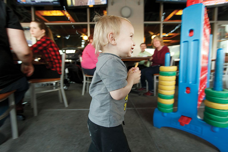 Trevor Skelton, 18 months, races around with french fry in hand on the patio at Ruckus Pizza, Pasta & Spirits in Morrisville, at Park West Village.