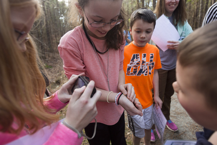 Norah Overcash catches a cricket frog and carefully opens her hand to show it to her sister Meredith, left, who takes a few photos, and Alex Erling, right. Joanne St. Clair explains that cricket frogs have their name be-cause the amphibians make the sound of two marbles clicking together.