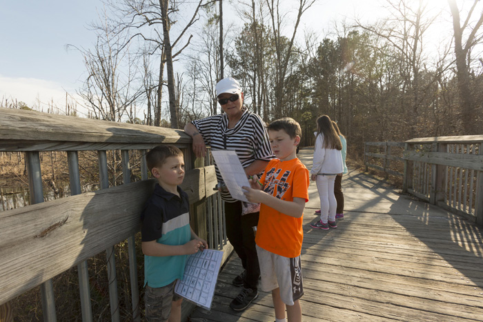 Marlene Bush, of Wake Forest, pauses on the bridge over Beaver Creek in Apex with her grand-sons Aiden, 7, and Alex Erling. Bush spends one weekend a month with the boys, and has enjoyed exploring area parks with them as they complete the Wake County Junior Park Naturalists program.