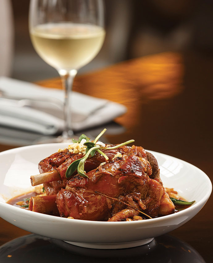 Pork osso bucco at Verandah comes with locally sourced hominy, great northern beans, crumbled goat cheese and wilted spinach.