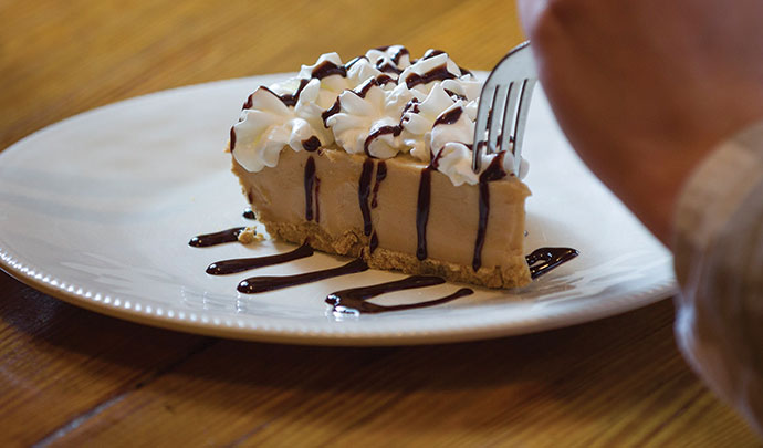 The Serendipity Gourmet Deli serves its house-made peanut butter pie topped with whipped cream and drizzled with chocolate syrup.