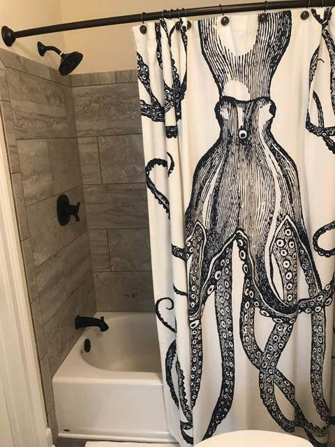 The octopus shower curtain fits the coastal vibe of the Florida home and is fun and memorable for renters.