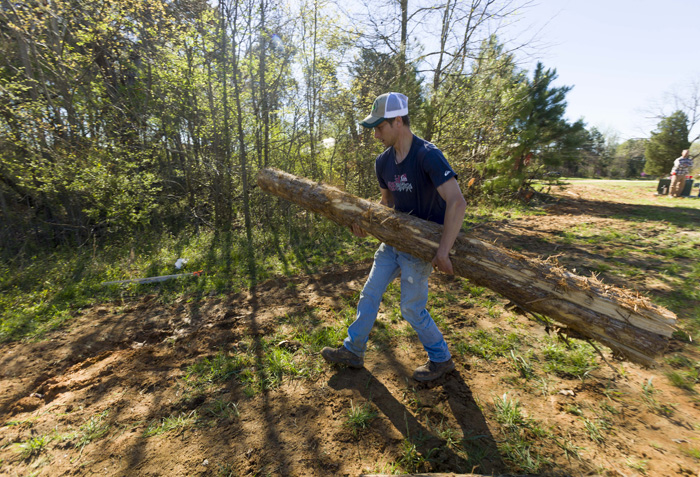 Farm manager Zeke Overbaugh helps build deer fencing at the farm. “I’m excited about this project because it means it’s becoming normal for towns and citizens to think about urban farming,” he says.