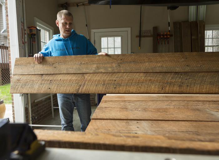 Jeff Thompson of Simple Roots Décor arranges reclaimed boards to create a rustic barn door to be used inside a client’s home. The wood came from a Lillington tobacco barn, built in 1903. “Barn doors are really big now,” he says, but the original barn doors are usually too weathered to be salvaged.