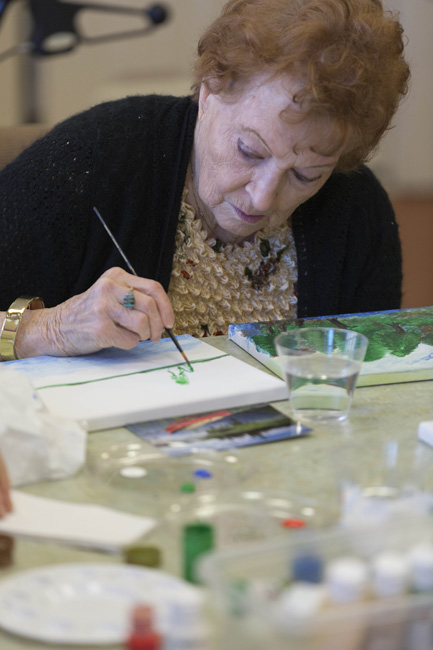 Joy Scott works on her latest landscape at a weekly art class for assisted living residents at Waltonwood in Cary. For seniors, “Art helps hand-eye coordination, and keeps the mind going through that thought process of creativity,” says Chester Williams, a retired art professor who recently added this class after teaching independent-living Waltonwood residents for more than four years.