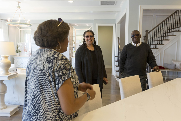 Real estate agent Peggy Dixon leads Joscie and Chris Barnes on a tour of the model home that their under-construction house is based on, featuring the amenities many house hunters are looking for, including granite countertops, hardwood floors, and a first-floor master. 