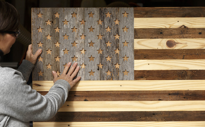 Diane Gemberling shows an American flag wall art that was part of a national giveaway on the Simple Roots Décor Facebook page. The 47-inch x 25-inch, natural tone American flag retails for $240, and roughly 35,000 people from all over submitted entries.