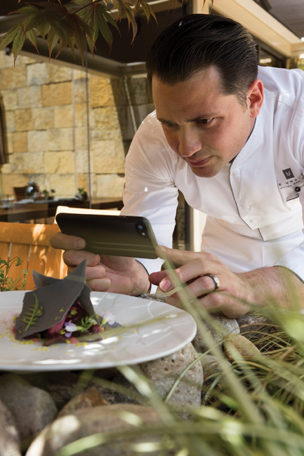 Heron’s executive chef Steven D. Greene photographs one of his creations at The Umstead Hotel and Spa patio. 