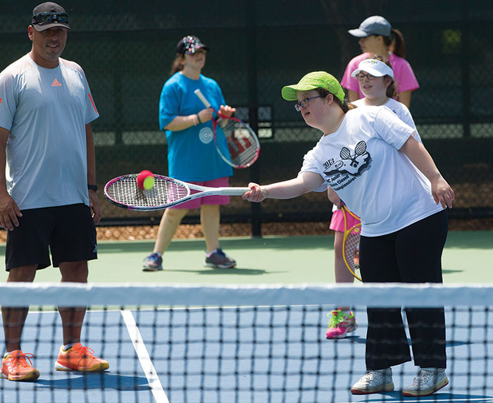 Melanie Santana, right, practices her forehand in front of Abilities Tennis Clinic coach Daniel Ebert at Cary Tennis Park. The Western Wake Tennis Association finds volunteers such as Ebert to help teach tennis clinics.