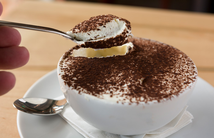 House-made tiramisu comes in a bowl dusted with cocoa powder.