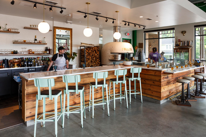 Cement flooring and wood-topped tables and an open kitchen add to the restaurant’s casual atmosphere.