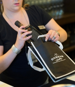 A bottle of Conniption Gin is packaged for a customer after a tour of Durham Distillery.