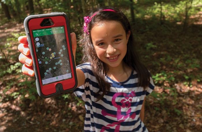 Delaney Feung searches for caches using the geocache app on her father’s phone.