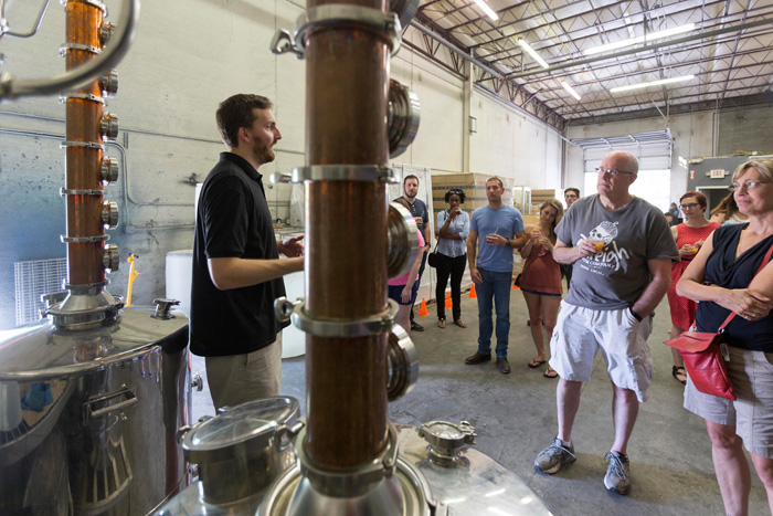 Matt Grossman, standing in front of Raleigh Rum’s two stills, explains to visitors how Louisiana molasses and brown sugar are distilled into rum.