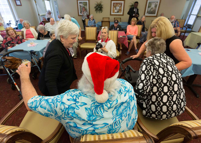 After singing Christmas carols with the four Santas, residents of Brookdale MacArthur Park sat with Santa and had their photos taken.