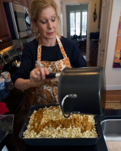 Vinson pours a hot mixture of brown sugar, butter, corn syrup, cream of tartar, salt, vanilla, and baking soda over plain popcorn.